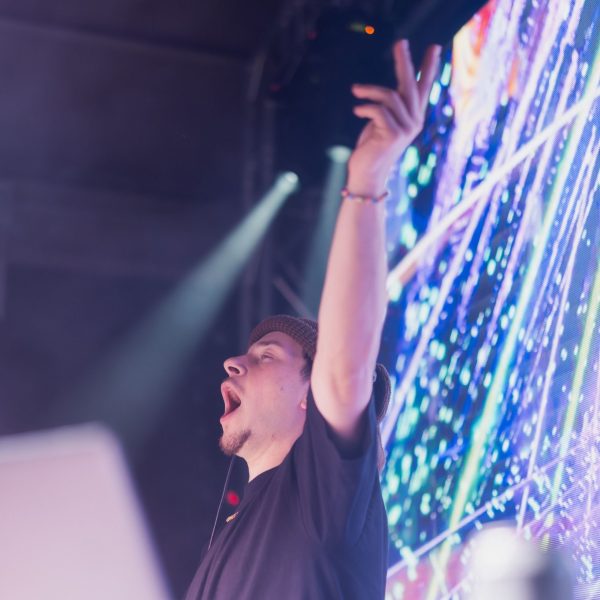 DJ arms up under stage lights, PCB Spring Break 2026