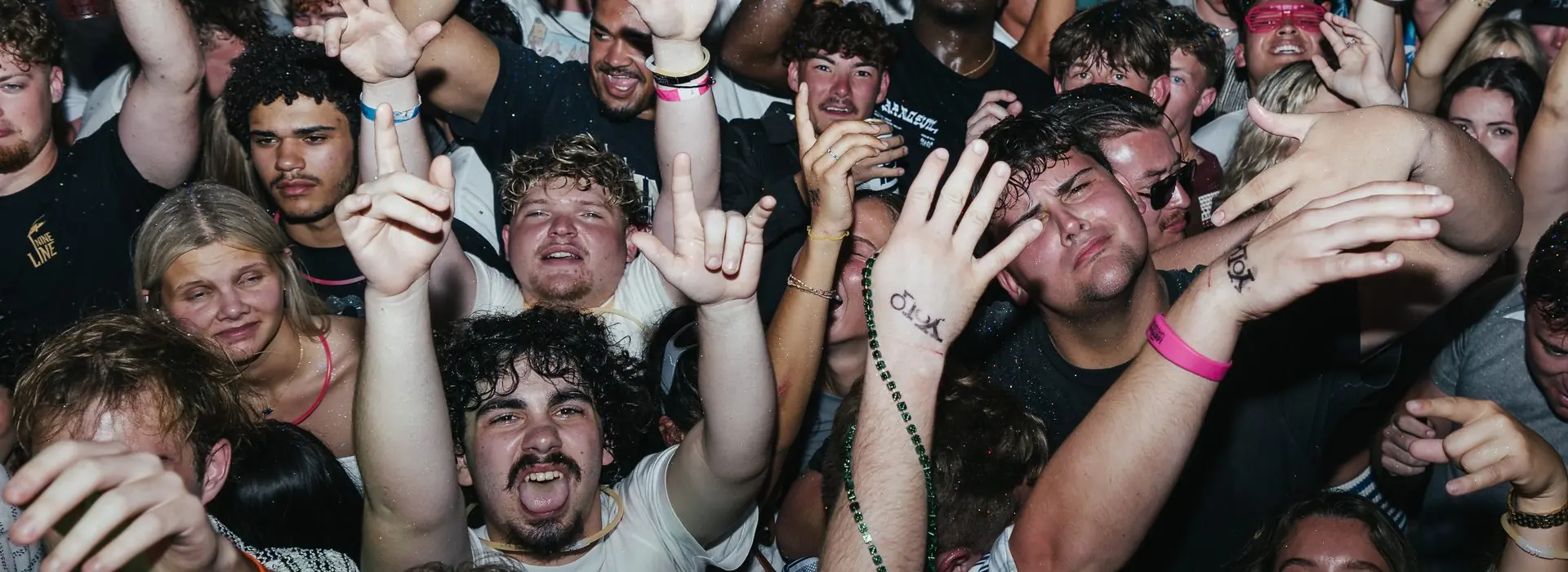 Crowd of college students with hands up at a PCB Club Card party during spring break 2026 in Panama City Beach