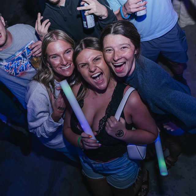 Three friends with a glow stick at PCB Spring Break 2026