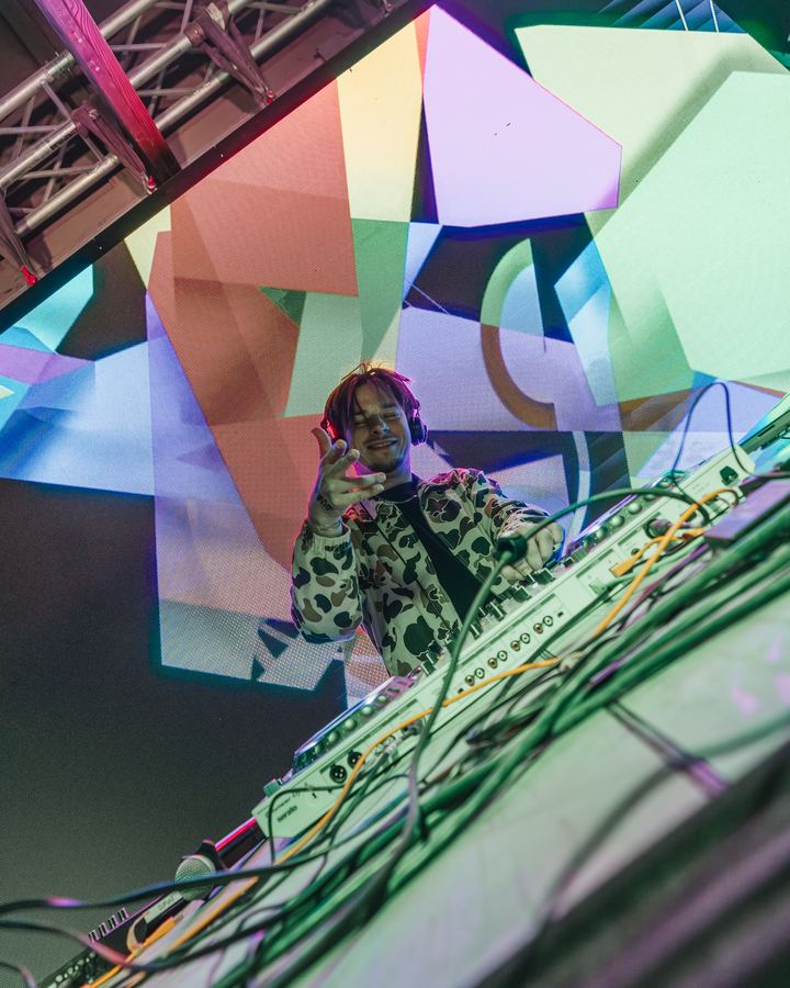 DJ in front of a colorful screen